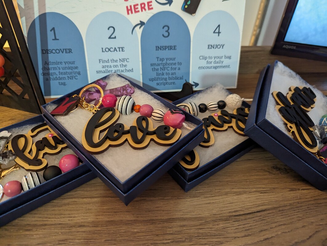 Boxed Link-A-Charm sets displayed next to a four-step instruction card